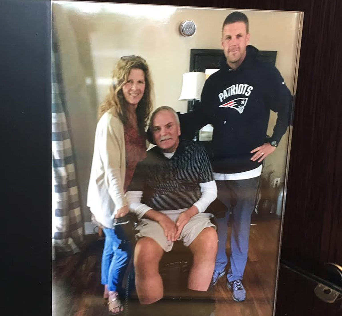 Billy Napier, far right, poses with his father, Bill, and mother, Pam, for a photograph that sits framed in his office.