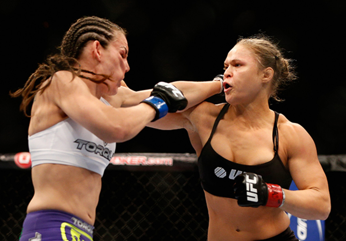 From right to left, UFC Women's Bantamweight champion Ronda Rousey punches Alexis Davis in their title fight at UFC 175 inside the Mandalay Bay Events Center in Las Vegas, Nevada.