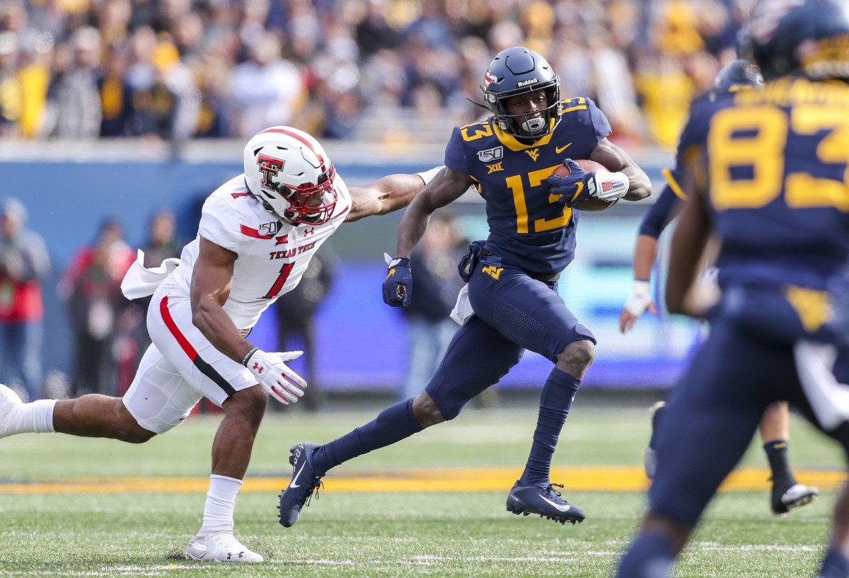 West Virginia Mountaineers wide receiver Sam James (13) runs after a catch against Texas Tech Red Raiders linebacker Jordyn Brooks (1) during the first quarter at Mountaineer Field at Milan Puskar Stadium.