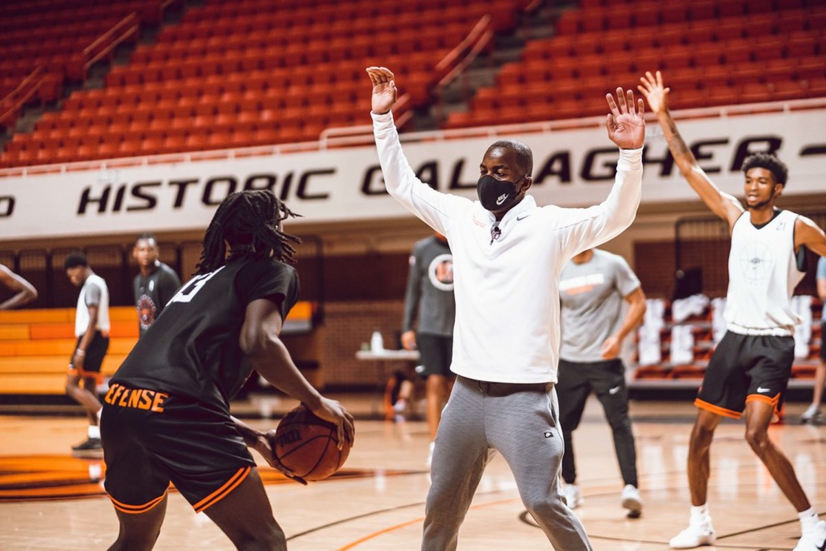 Head coach Mike Boynton mixes is up with players in the half court in the first practice of the season.