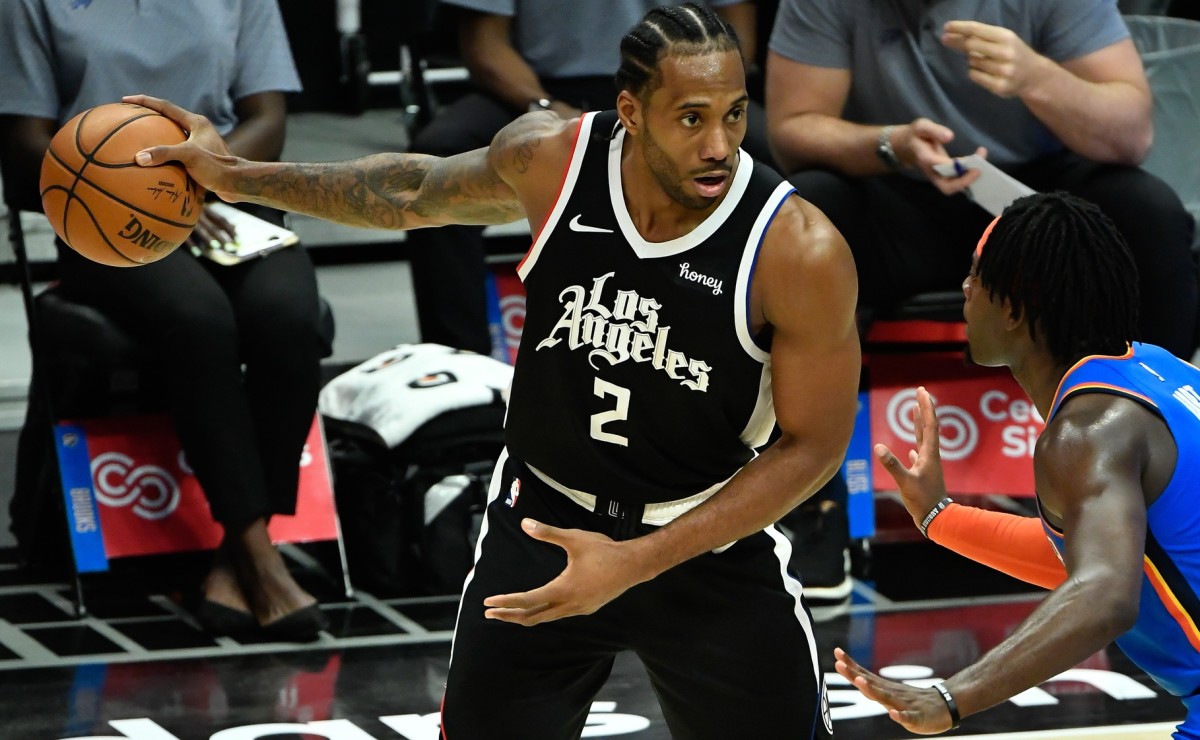 Jan 22, 2021; Los Angeles, California, USA; LA Clippers forward Kawhi Leonard (2) keeps the ball away from Oklahoma City Thunder forward Luguentz Dort (5) during the fourth qiuarter at Staples Center. Mandatory Credit: Robert Hanashiro-USA TODAY Sports