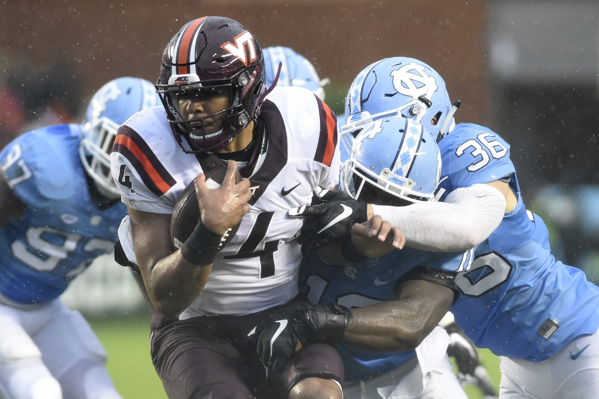 Oct 8, 2016; Chapel Hill, NC, USA; Virginia Tech Hokies quarterback Jerod Evans (4) is tackled by North Carolina Tar Heels linebackers Andre Smith (10) and Cole Holcomb (36) in the first half at Kenan Memorial Stadium. Mandatory Credit: Bob Donnan-USA TODAY Sports