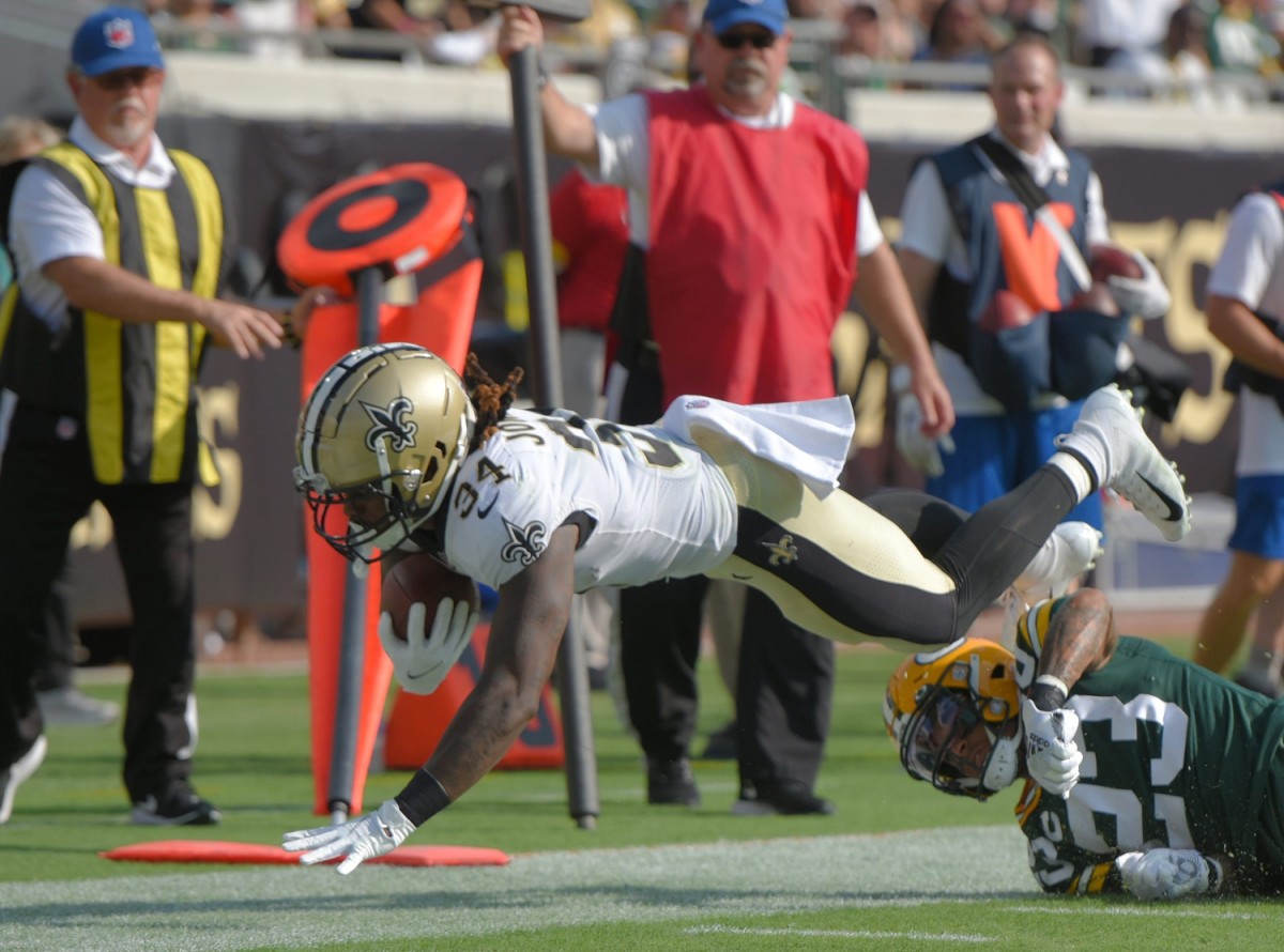 New Orleans Saints RB (34) Tony Jones Jr. dives over Green Bay cornerback Jaire Alexander (23) © Bob Self/Florida Times-Union via Imagn Content Services, LLC