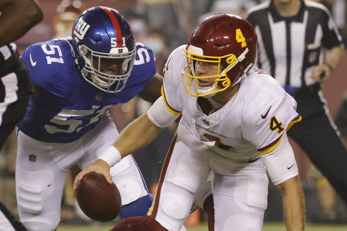 Sep 16, 2021; Landover, Maryland, USA; Washington Football Team quarterback Taylor Heinicke (4) is sacked by New York Giants linebacker Azeez Ojulari (51) in the first quarter at FedExField.