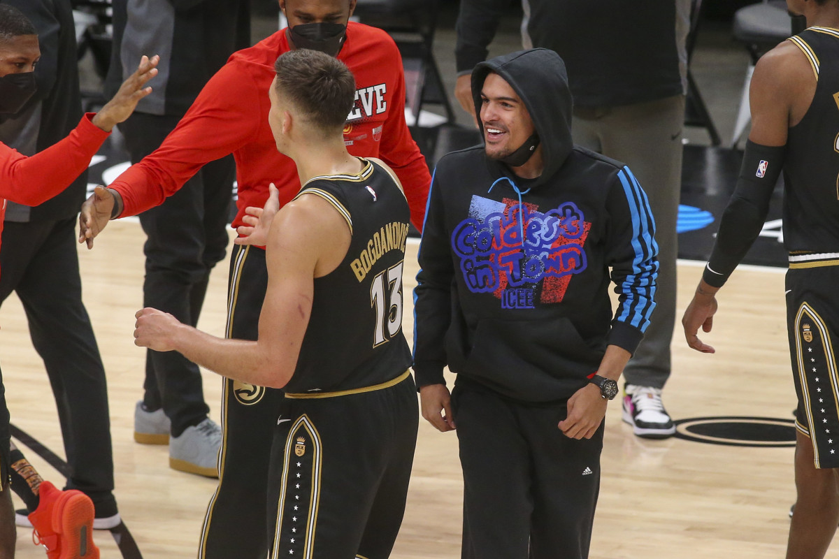 Atlanta Hawks guard Trae Young (11) celebrates with guard Bogdan Bogdanovic (13) during a timeout against the Milwaukee Bucks in the third quarter during game four of the Eastern Conference Finals for the 2021 NBA Playoffs at State Farm Arena.