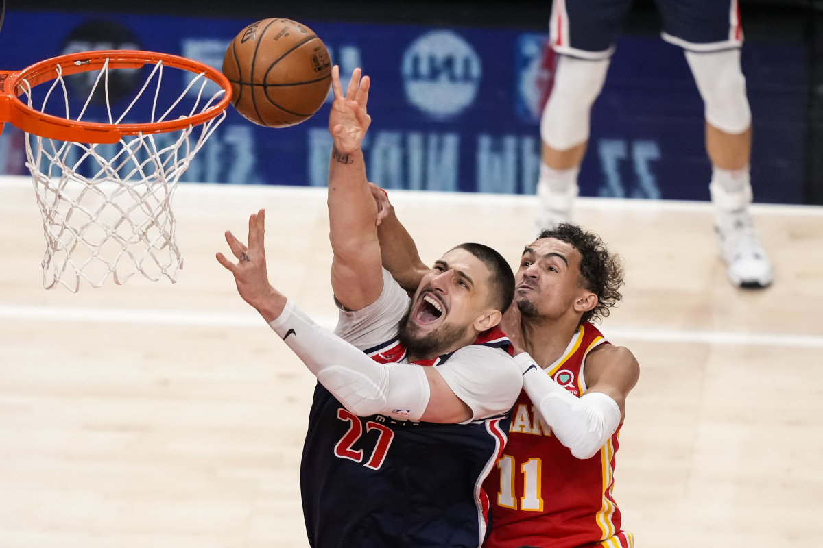Washington Wizards center Alex Len (27) gets fouled from behind by Atlanta Hawks guard Trae Young (11) during the second half at State Farm Arena.