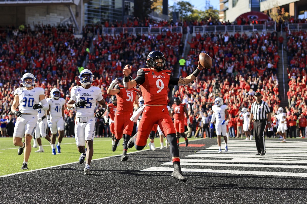 Nov 6, 2021; Cincinnati, Ohio, USA; Cincinnati Bearcats quarterback Desmond Ridder (9) runs with the ball for a touchdown against the Tulsa Golden Hurricane in the first half at Nippert Stadium. Mandatory Credit: Aaron Doster-USA TODAY Sports