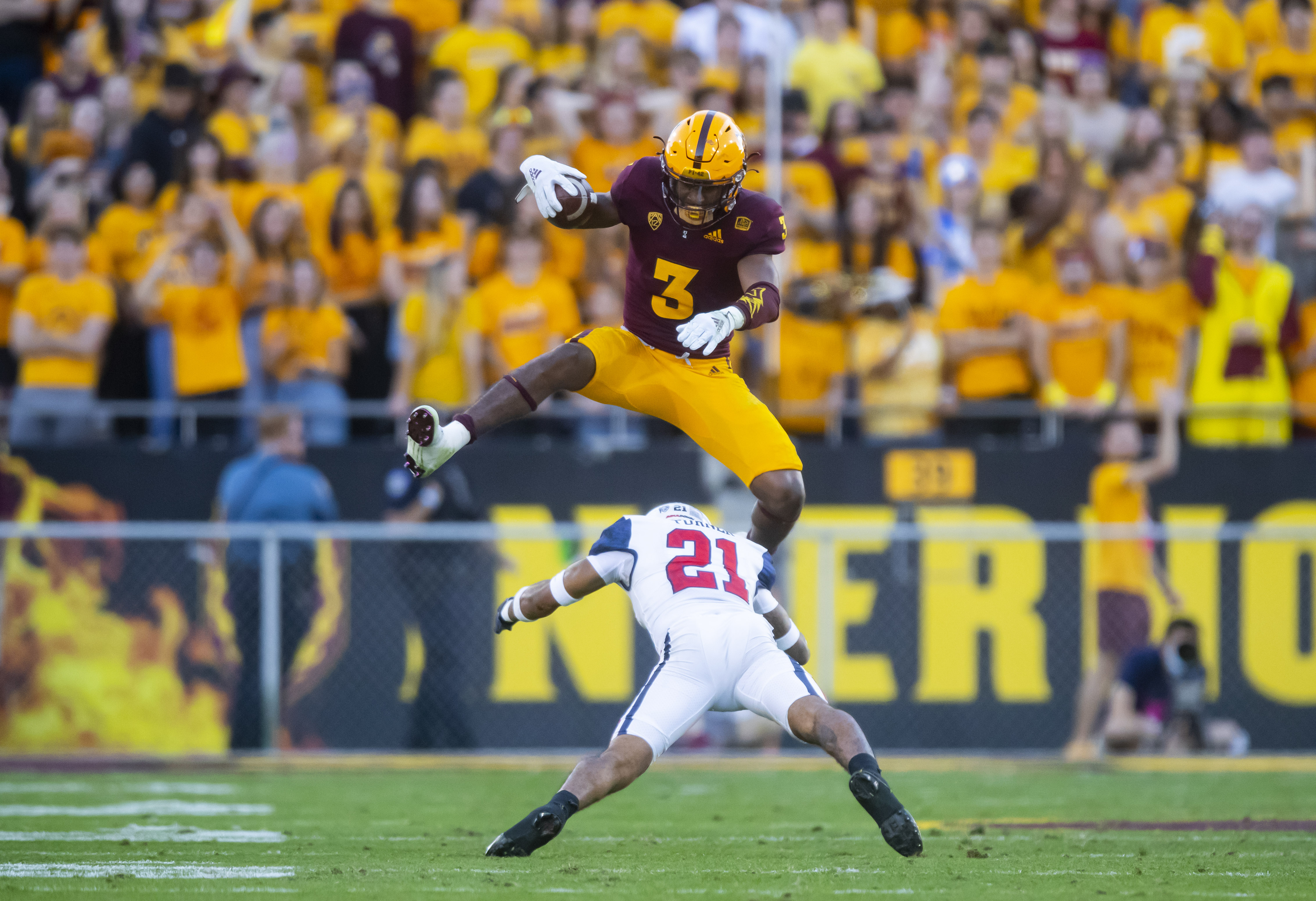 Nov 27, 2021; Tempe, Arizona, USA; Arizona State Sun Devils running back Rachaad White (3) jumps over Arizona Wildcats safety Jaxen Turner (21) during the second half at Sun Devil Stadium. Mandatory Credit: Mark J. Rebilas-USA TODAY Sports