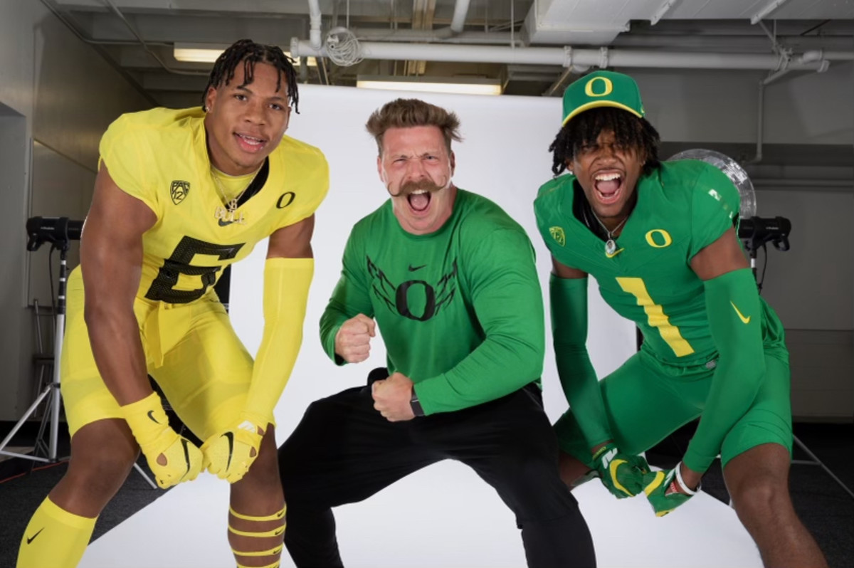 Aaron Feld flexes during a photo shoot with Oregon WR commit Stephon Johnson Jr. (1) and Oregon LB Target TJ Dudley (6).