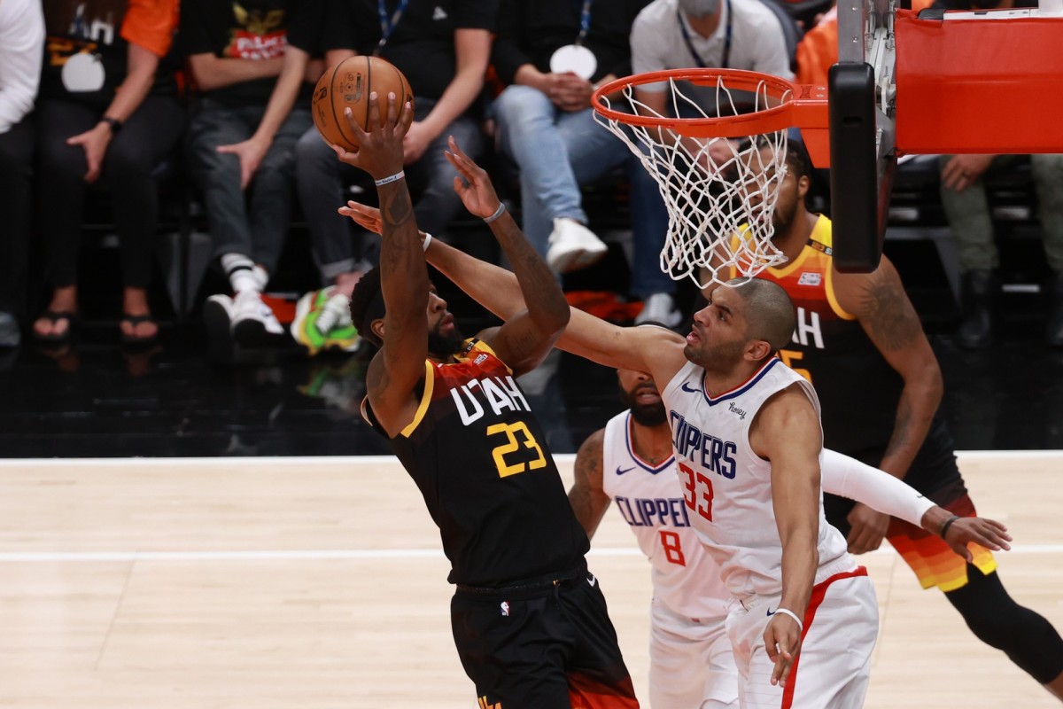 Royce O'Neale (23) scores over Nicolas Batum (33)