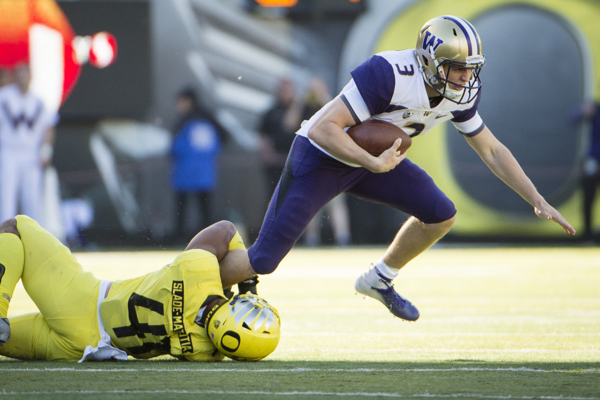 Isaac Slade-Matautia (41) clutches onto Washington quarterback Jake Browning's (3) leg for a tackle for loss.