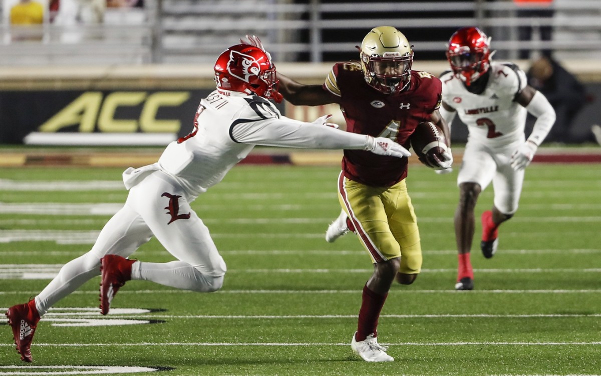 Nov 28, 2020; Chestnut Hill, Massachusetts, USA; Boston College Eagles wide receiver Zay Flowers (4) stiff arms Louisville Cardinals defensive back Russ Yeast (3) during the first half at Alumni Stadium.
