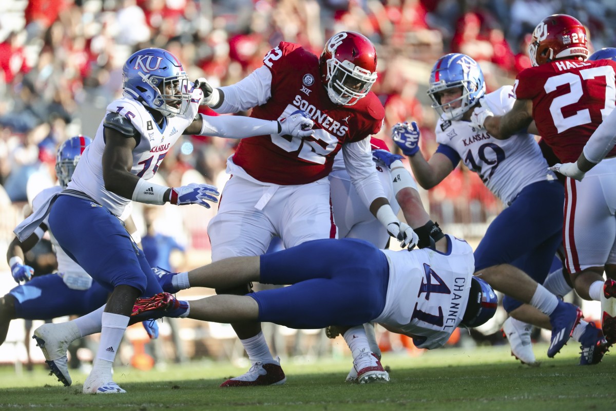 Nov 7, 2020; Norman, Oklahoma, USA; Oklahoma Sooners offensive lineman Tyrese Robinson (52) blocks Kansas Jayhawks linebacker Kyron Johnson (15) and linebacker Nick Channel (41) during the first half against the Kansas Jayhawks at Gaylord Family-Oklahoma Memorial Stadium.