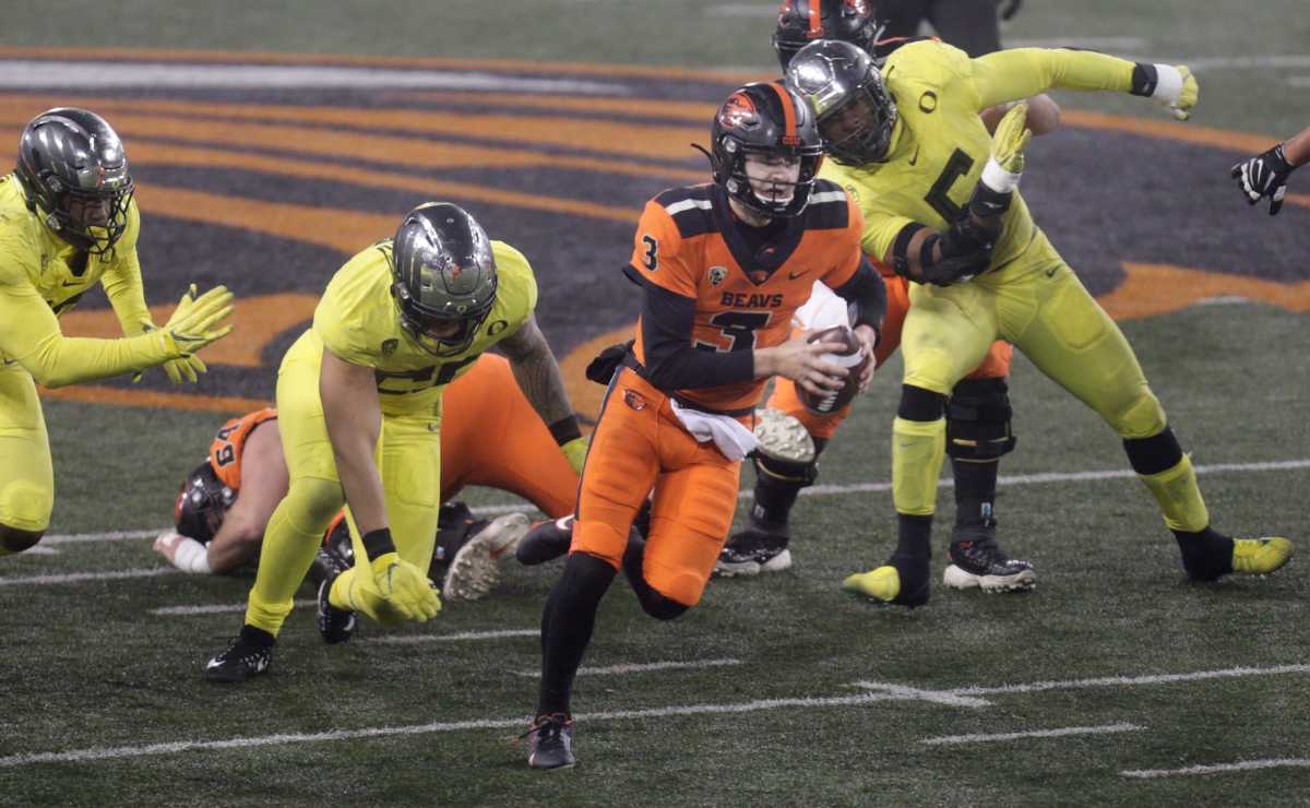 Oregon State quarterback Tristan Gebbia (3) runs through the Oregon defensive line on a quarterback keeper during the Beavers' 41-38 upset win over the Ducks on Nov. 27, 2020.