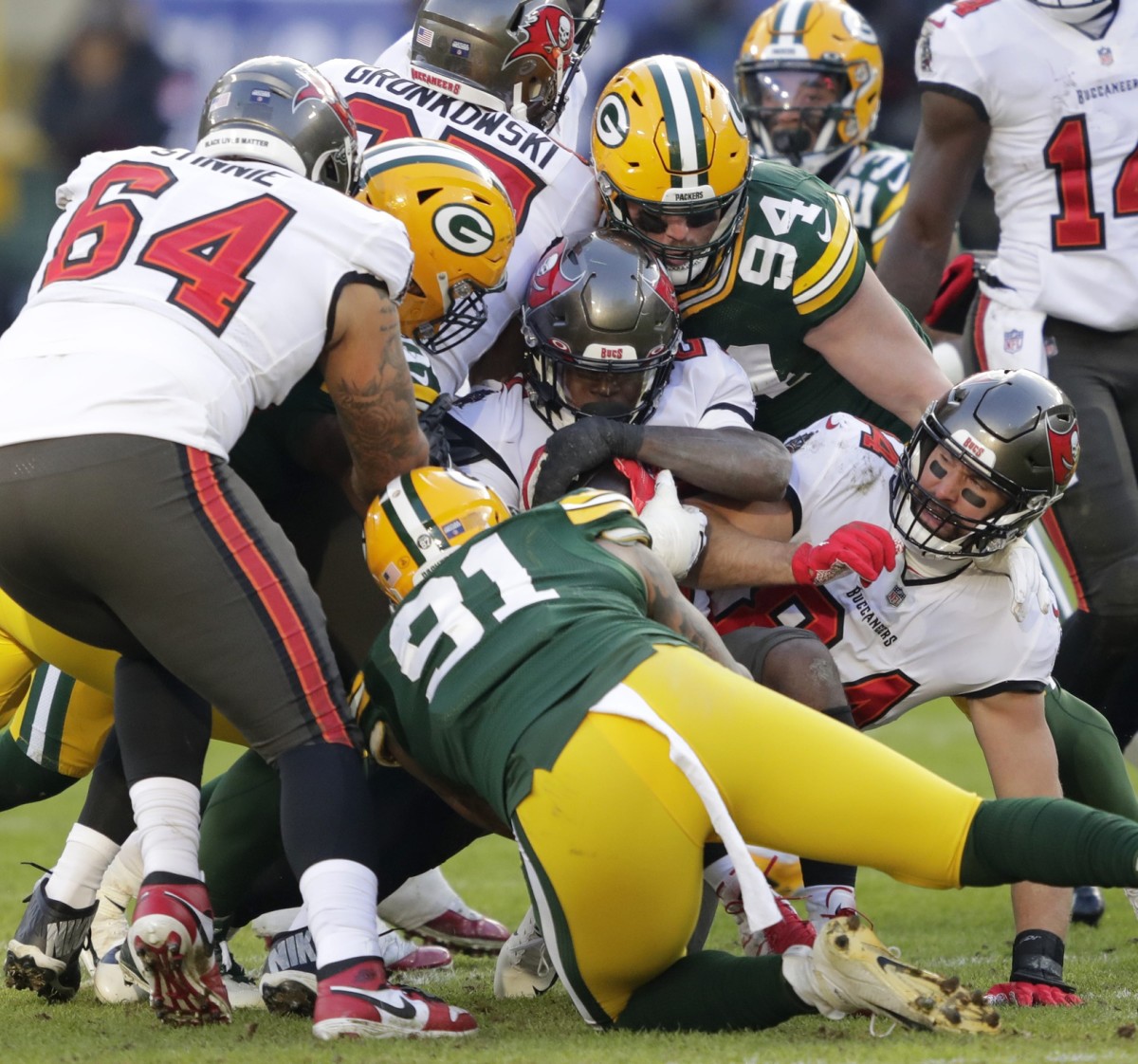 Tampa Bay running back Ronald Jones (27) is stopped by Green Bay Packers Kenny Clark during the NFC championship game. © Dan Powers/USA TODAY NETWORK-Wis via Imagn Content Services, LLC
