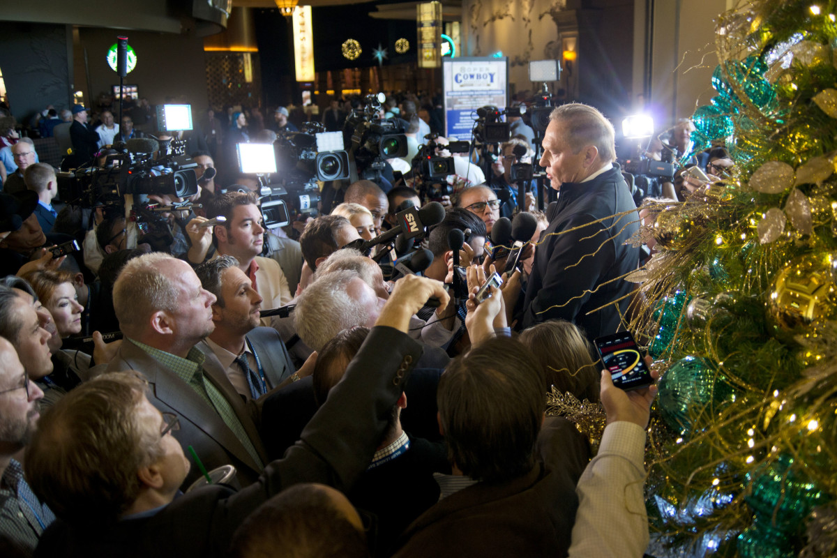 Sports agent Scott Boras talks in front of a giant christmas tree as media members gather in front of him