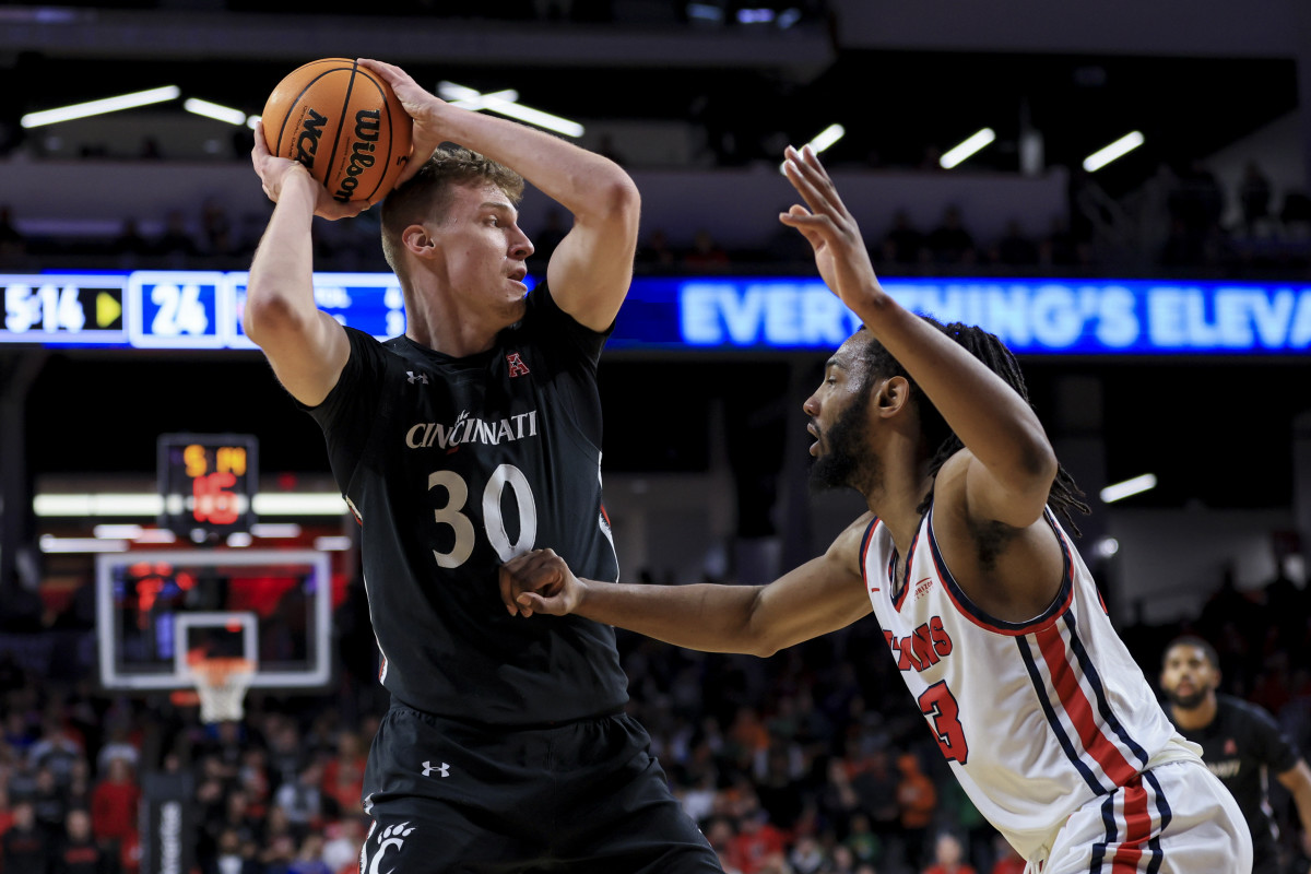 Dec 21, 2022; Cincinnati, Ohio, USA; Cincinnati Bearcats forward Viktor Lakhin (30) controls the ball against Detroit Mercy Titans forward Damezi Anderson (23) in the first half at Fifth Third Arena. Mandatory Credit: Aaron Doster-USA TODAY Sports