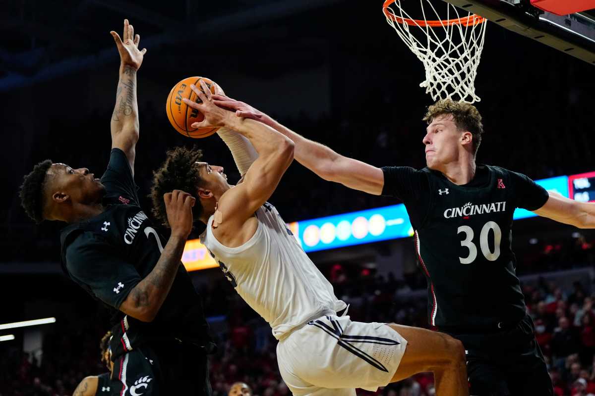 Cincinnati Bearcats forward Viktor Lakhin (30) blocks a shot by Xavier Musketeers guard Colby Jones (3) in the second half of the 90th Annual Crosstown Shootout NCAA basketball game between the Cincinnati Bearcats and the Xavier Musketeers at Fifth Third Arena in Cincinnati on Saturday, Dec. 10, 2022. The Musketeers held on down the stretch for a 80-77 win. Crosstown Shootout