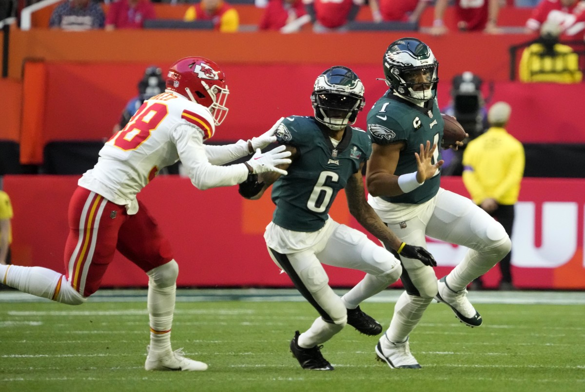 Feb 12, 2023; Glendale, AZ, USA; Philadelphia Eagles quarterback Jalen Hurts (1) scrambles with the ball as wide receiver DeVonta Smith (6) blocks Kansas City Chiefs cornerback L'Jarius Sneed (38) during the first quarter in Super Bowl LVII at State Farm Stadium.
