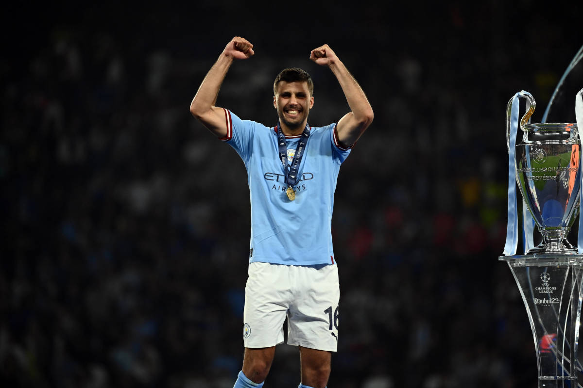 Rodri pictured standing next to the UEFA Champions League trophy after scoring the winning goal for Manchester City in the 2023 final