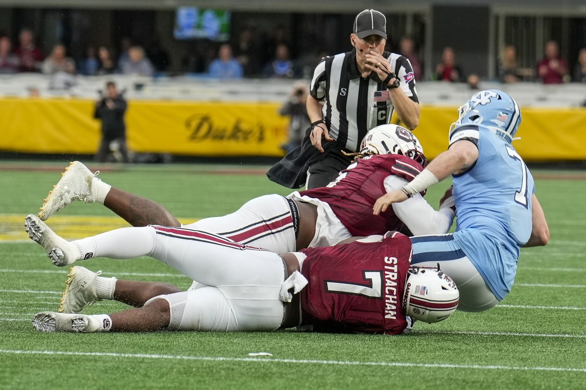 North Carolina Tar Heels quarterback Sam Howell (7) is sacked by South Carolina Gamecocks defensive lineman Zacch Pickens (6) and defensive end Jordan Strachan (7) during the second quarter at Bank of America Stadium. Mandatory Credit: Jim Dedmon-USA TODAY Sports
