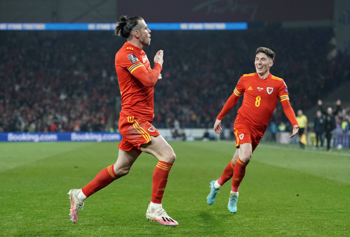 Gareth Bale pats the crest on his shirt after scoring against Austria in a 2022 World Cup qualifier