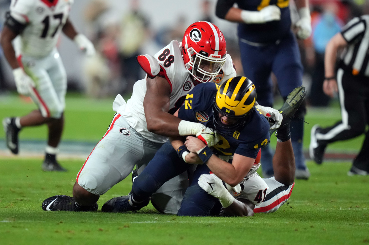 Jalen Carter wraps up Michigan quarterback Cade McNamara during the Orange Bowl.