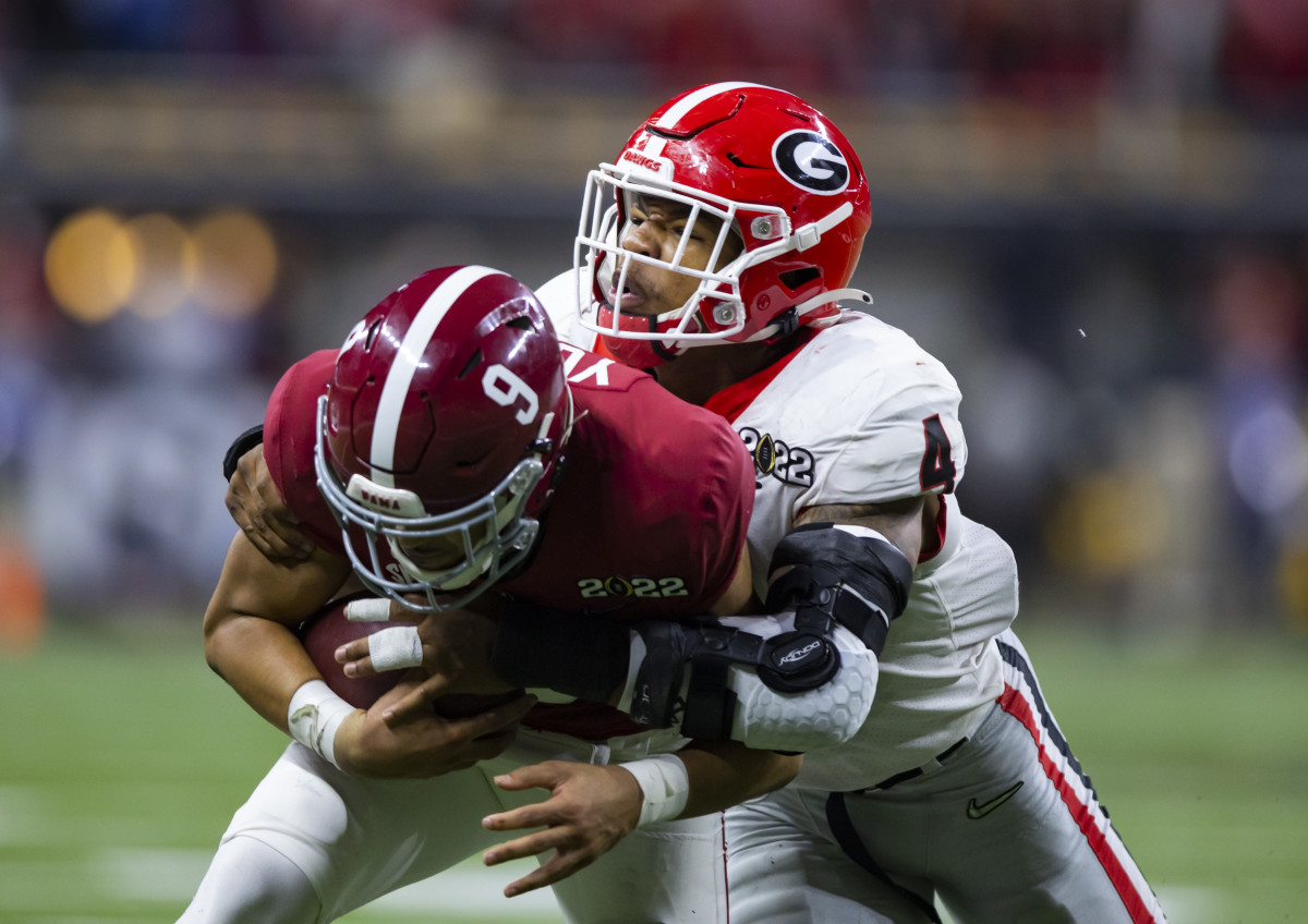 Nolan Smith brings down Alabama quarterback Bryce Young in the 2021-2022 national championship game.