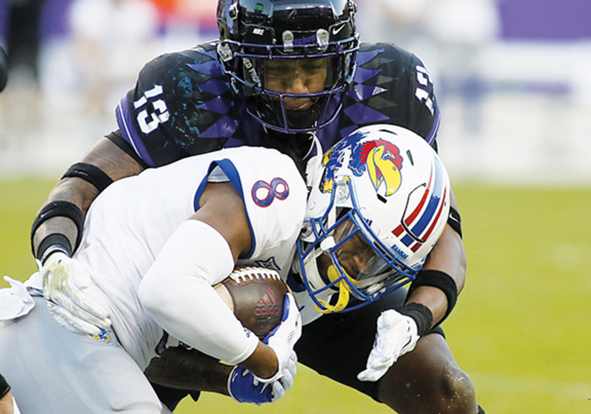 TCU's Dee Winters tackles Kansas receiver Kwamie Lassiter.