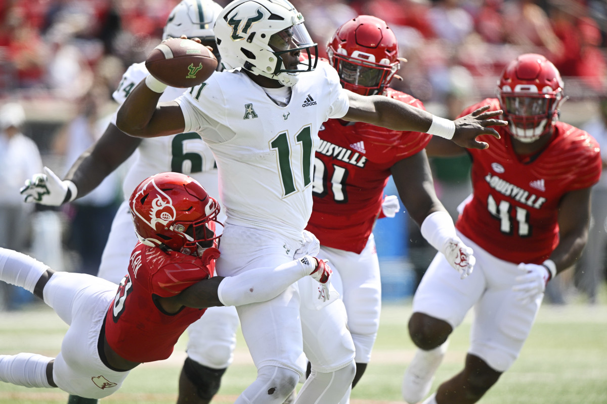 Sep 24, 2022; Louisville, Kentucky, USA; South Florida Bulls quarterback Gerry Bohanon (11) throws a pass under the pressure of Louisville Cardinals defensive back Kei'Trel Clark (13) during the second quarter at Cardinal Stadium. Mandatory Credit: Jamie Rhodes-USA TODAY Sports