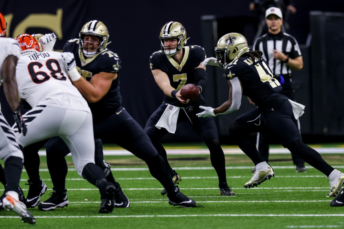 New Orleans Saints Taysom Hill (7) holds the ball off to running back Alvin Kamara (41) against the Cincinnati Bengals. Mandatory Credit: Stephen Lew-USA TODAY Sports
