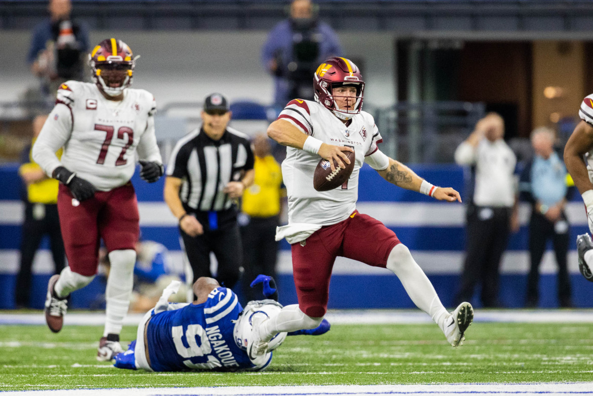 Oct 30, 2022; Indianapolis, Indiana, USA; Washington Commanders quarterback Taylor Heinicke (4) runs the ball while Indianapolis Colts defensive end Yannick Ngakoue (91) defends in the second quarter at Lucas Oil Stadium.