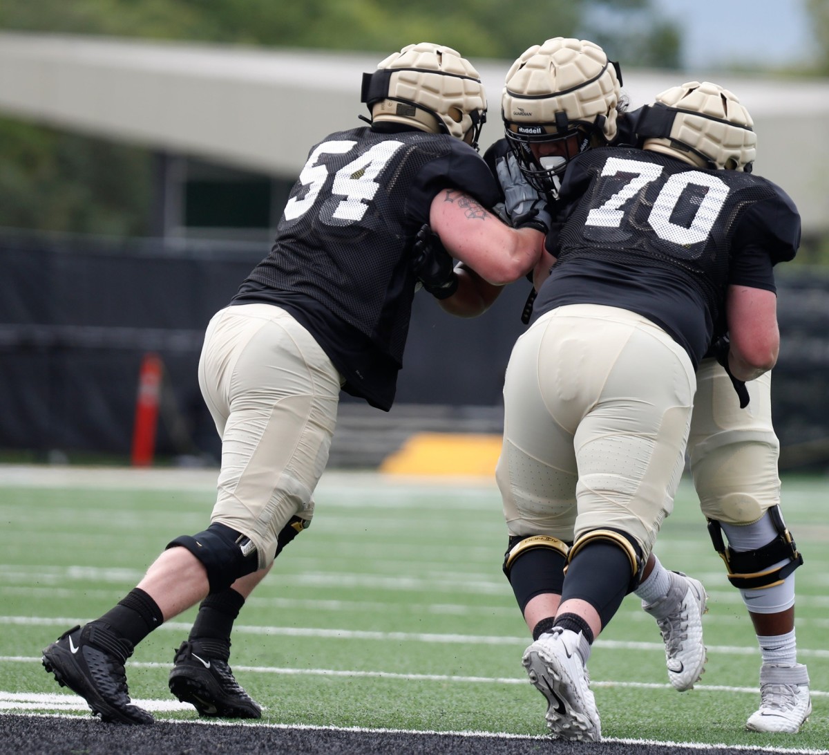 Purdue Boilermakers offensive lineman Josh Kaltenberger (54) and Purdue Boilermakers offensive lineman Zach Richards (70) block Purdue Boilermakers offensive lineman Sione Finau (72) during practice at Purdue University in West Lafayette, Ind.