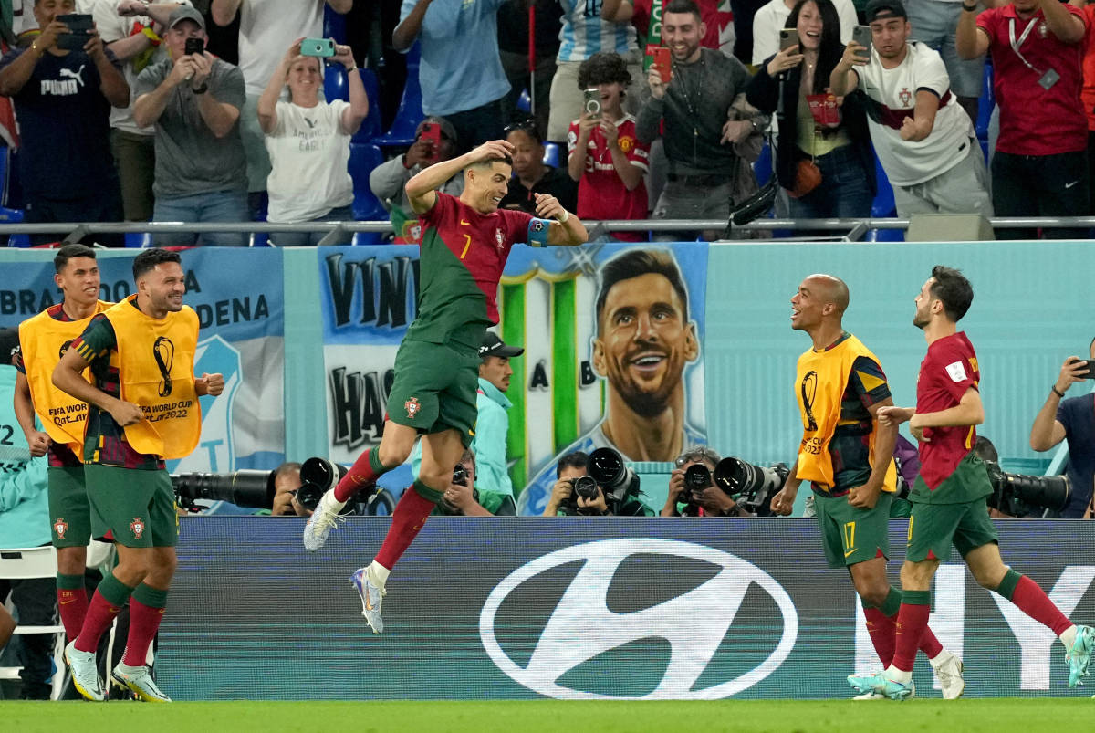Cristiano Ronaldo pictured jumping in the air to celebrate the goal that made him the first player ever to score at five different FIFA World Cups