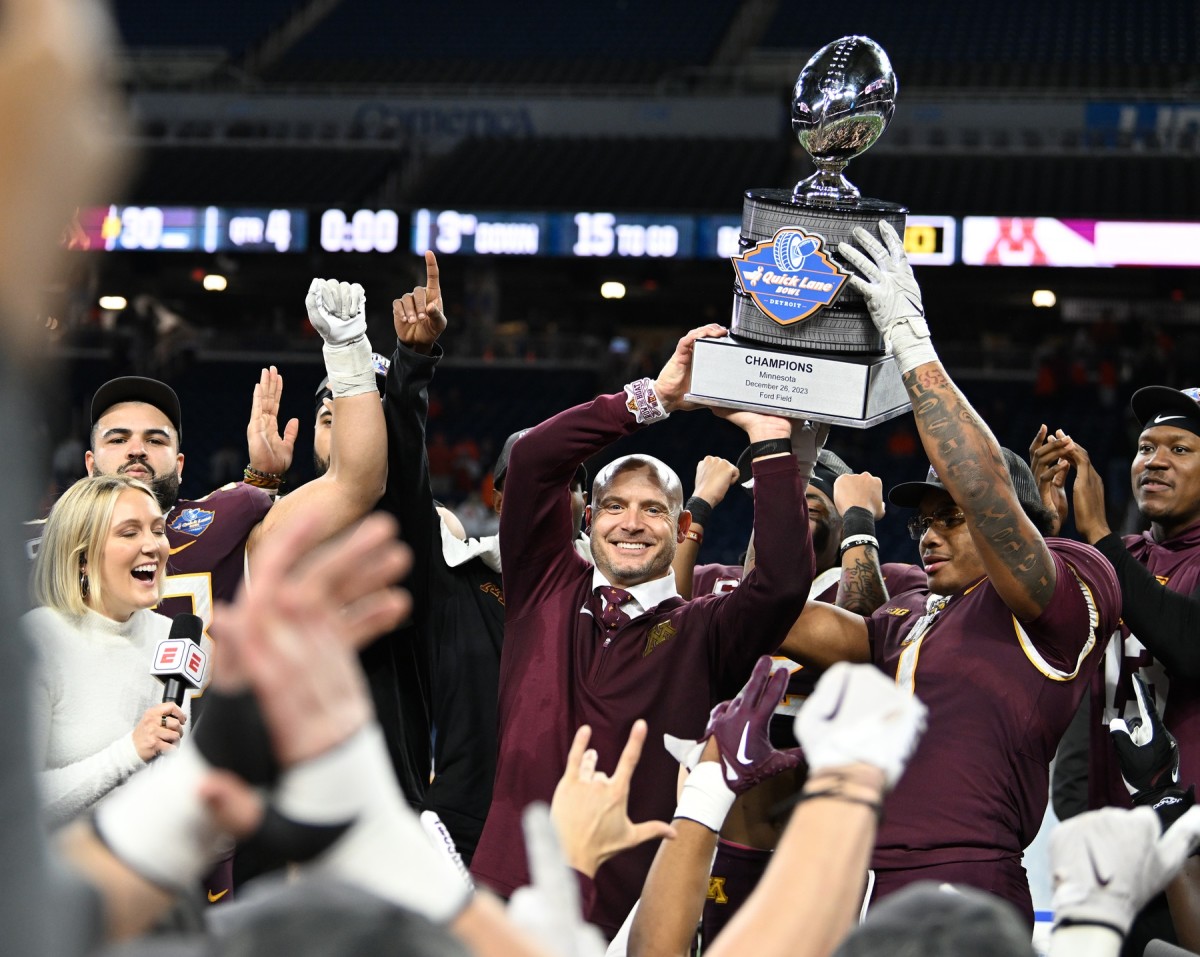 Dec 26, 2023; Detroit, MI, USA; Minnesota Golden Gophers running back Darius Taylor (1) and head coach P.J. Fleck hold up the Quick Lane Bowl trophy after defeating the Bowling Green Falcons at Ford Field.