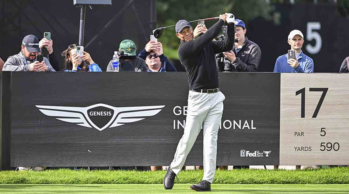 Tiger Woods plays his shot from the 17th tee while members of the media take video and photos behind him during practice for the 2024 Genesis Invitational at Riviera Country Club in Pacific Palisades, Calif.