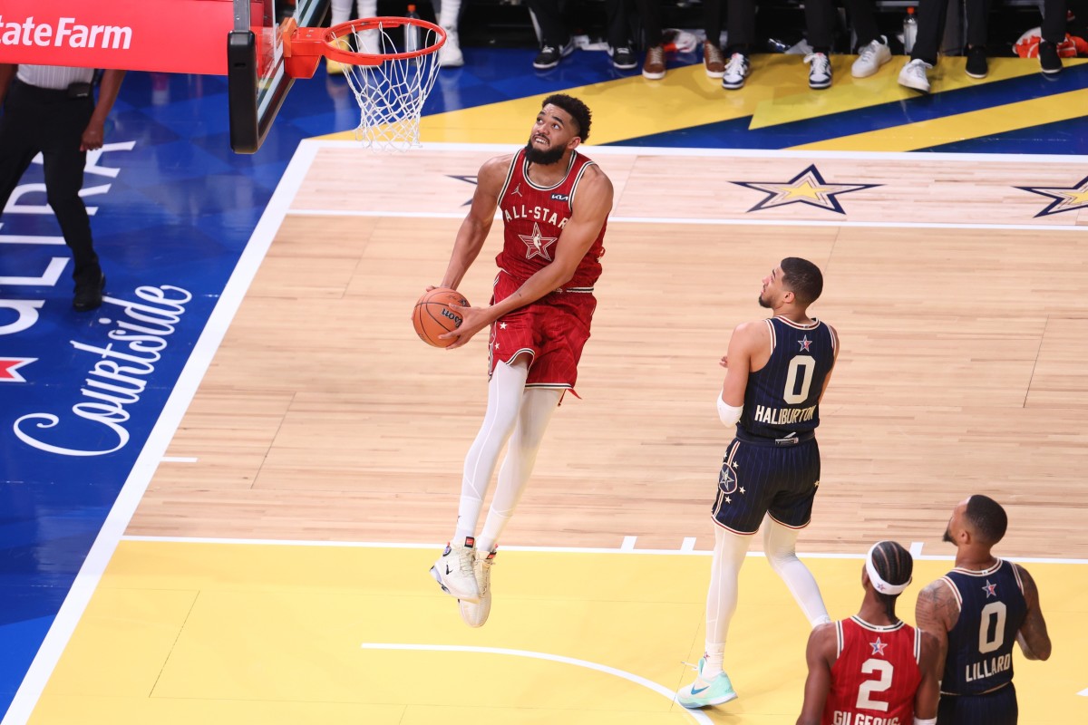 Feb 18, 2024; Indianapolis, Indiana, USA; Western Conference center Karl-Anthony Towns (32) of the Minnesota Timberwolves dunks the ball past Eastern Conference guard Tyrese Halliburton (0) of the Indiana Pacers during the fourth quarter in the 73rd NBA All Star game at Gainbridge Fieldhouse.