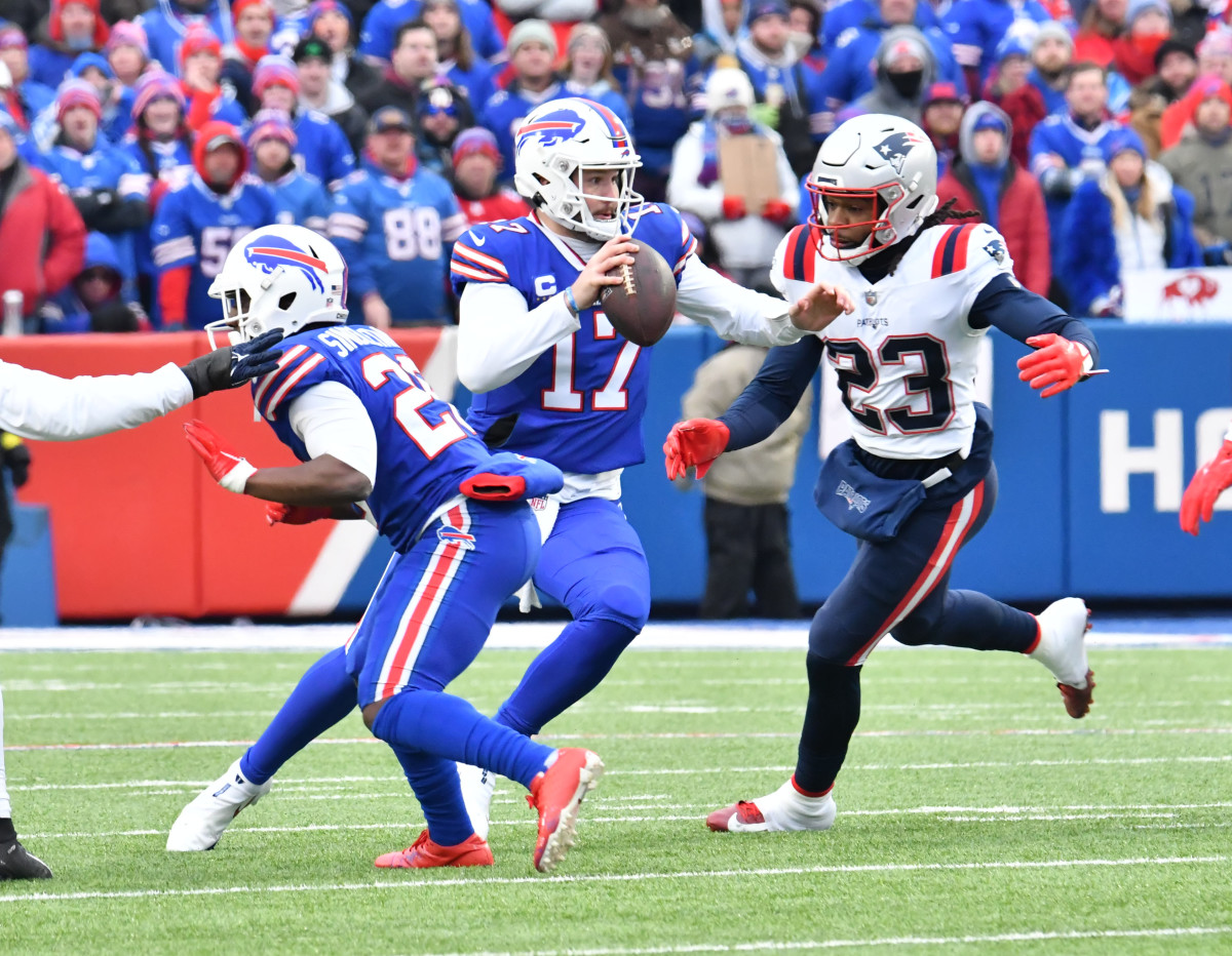 Jan 8, 2023; Orchard Park, New York, USA; Buffalo Bills quarterback Josh Allen (17) is pressured by New England Patriots safety Kyle Dugger (23) in the first quarter at Highmark Stadium. 