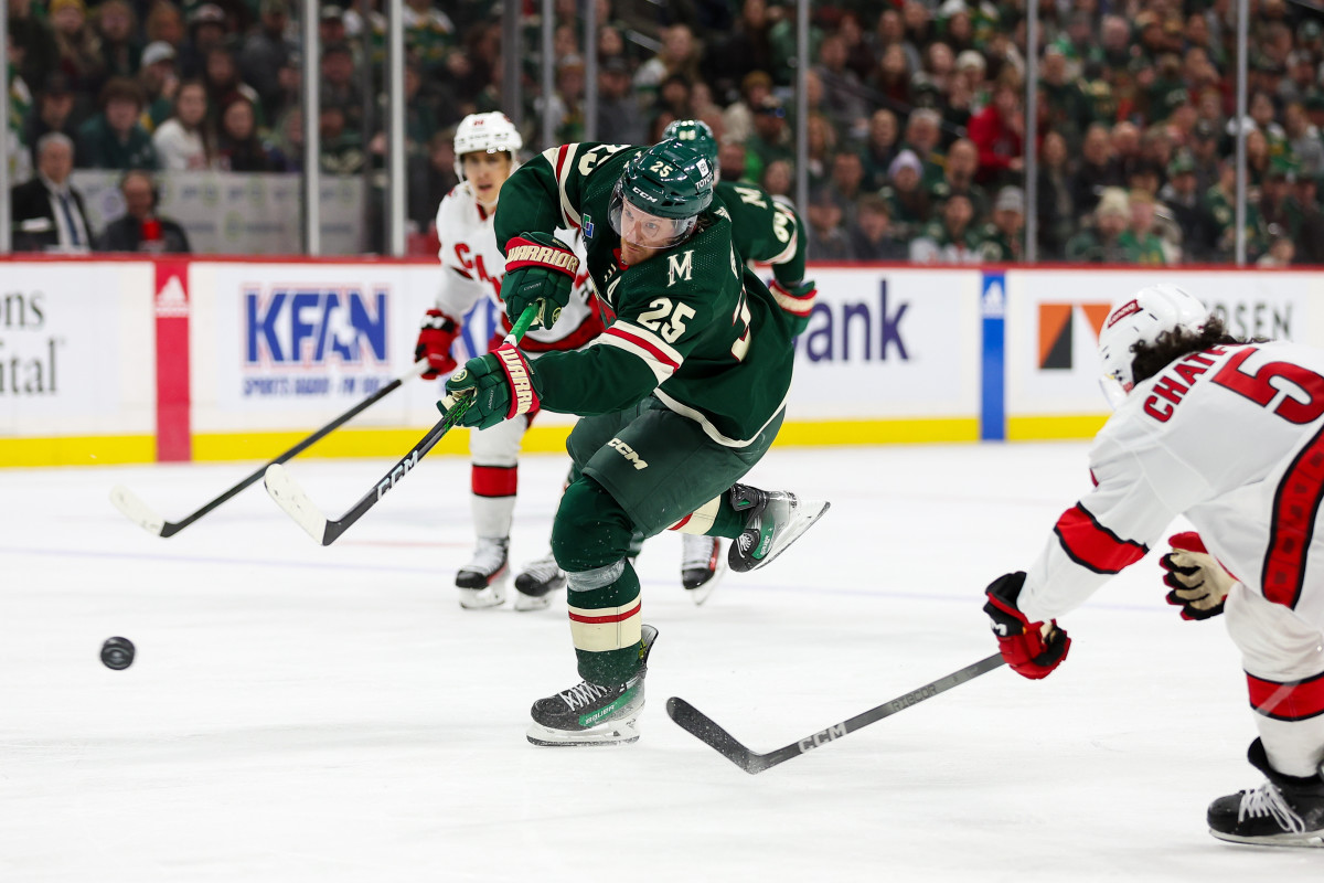 Feb 27, 2024; Saint Paul, Minnesota, USA; Minnesota Wild defenseman Jonas Brodin (25) shoots as Carolina Hurricanes defenseman Jalen Chatfield (5) defends during the second period at Xcel Energy Center.