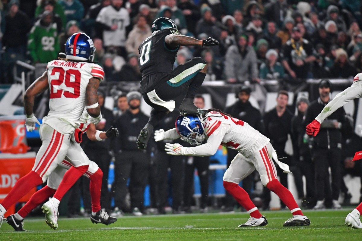 Dec 25, 2023; Philadelphia, Pennsylvania, USA; Philadelphia Eagles running back D'Andre Swift (0) leaps over New York Giants safety Dane Belton (24) during the fourth quarter at Lincoln Financial Field.