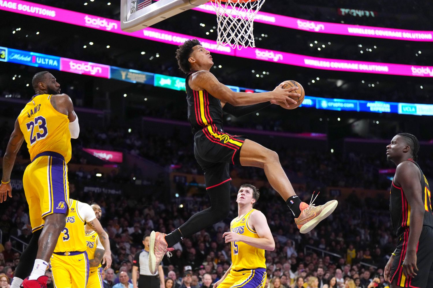 Mar 18, 2024; Los Angeles, California, USA; Atlanta Hawks forward Jalen Johnson (1) dunks the ball against Los Angeles Lakers forward LeBron James (23) in the first half at Crypto.com Arena. Mandatory Credit: Kirby Lee-USA TODAY Sports