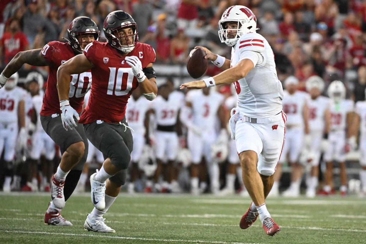 Sep 9, 2023; Pullman, Washington, USA; Wisconsin Badgers quarterback Tanner Mordecai (8) throws a pass against Washington State Cougars defensive end Ron Stone Jr. (10) in the second half at Gesa Field at Martin Stadium. Washington State won 31-22. Mandatory Credit: James Snook-USA TODAY Sports