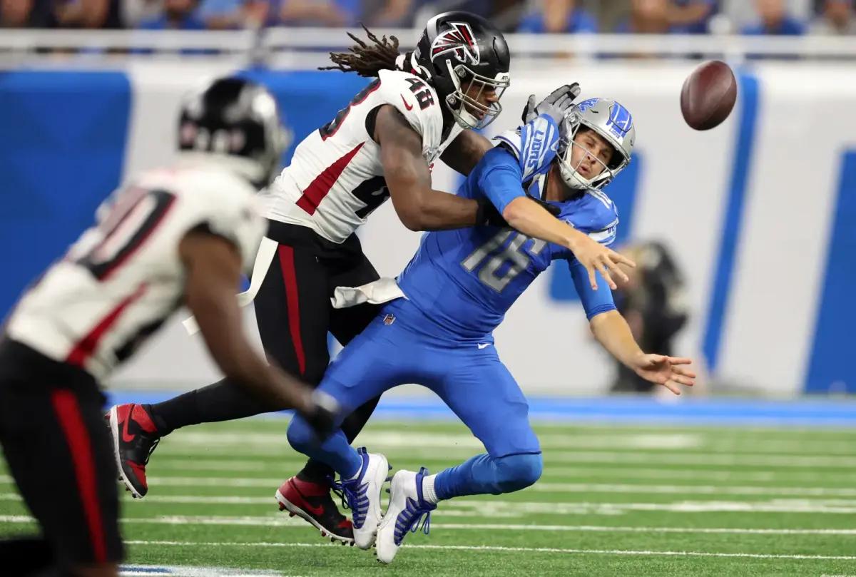 DETROIT, MICHIGAN - SEPTEMBER 24: Jared Goff #16 of the Detroit Lions is hit as he passes by Bud Dupree #48 of the Atlanta Falcons in the third quarter of a game at Ford Field on September 24, 2023 in Detroit, Michigan.