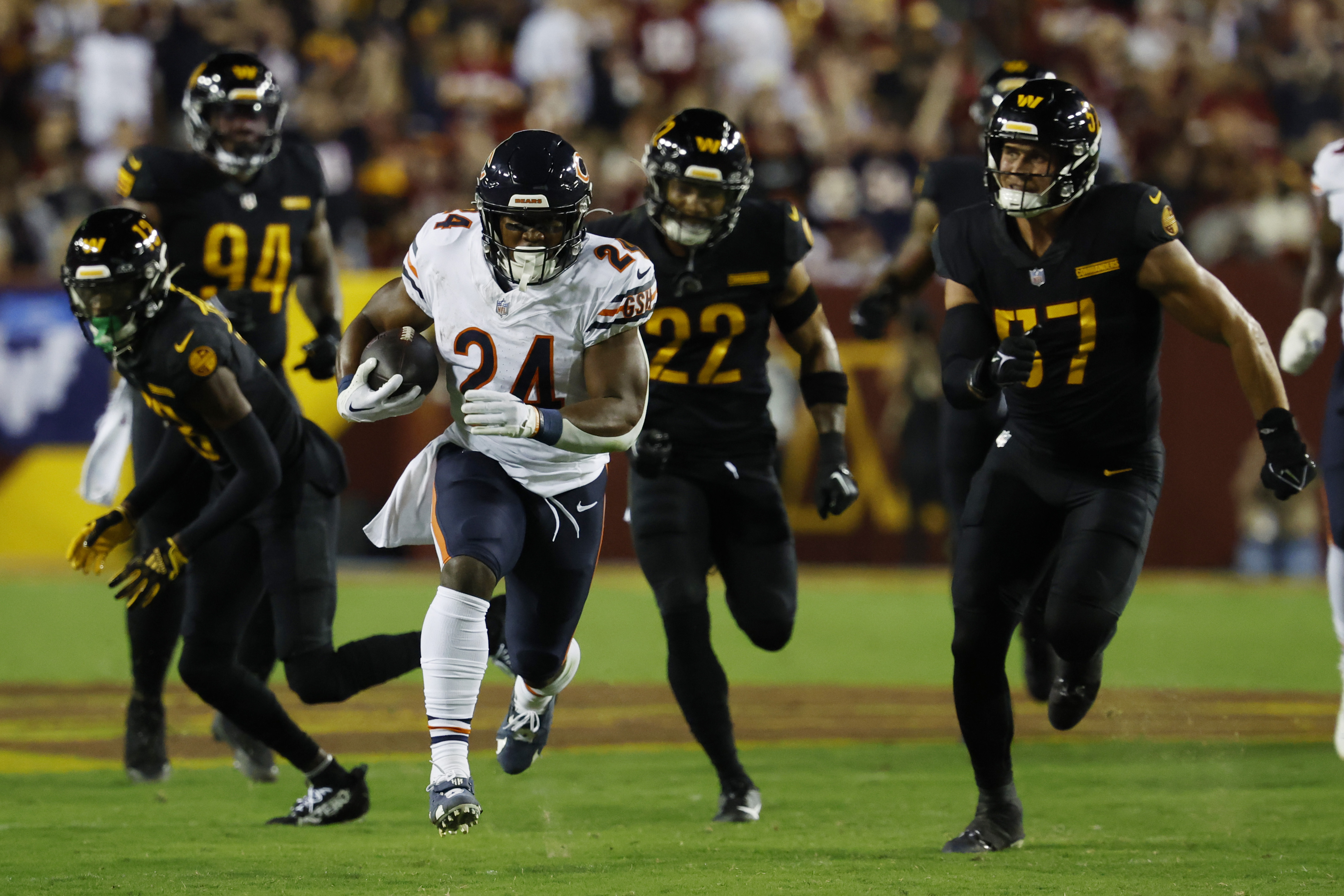 Chicago Bears running back Khalil Herbert (24) carries the ball as Washington Commanders linebacker Cody Barton (57) chases during the first quarter at FedExField.