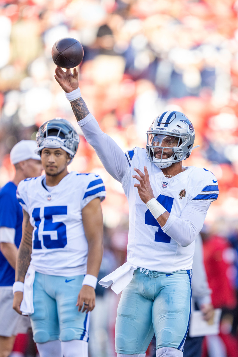 Dallas Cowboys quarterback Dak Prescott warms up in front of quarterback Trey Lance