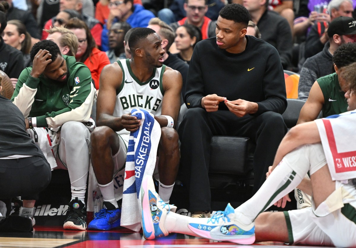 Milwaukee Bucks forward Thanasis Antetokounmpo (34) speaks with his brother, forward Giannis Antetokounmpo at the team bench 