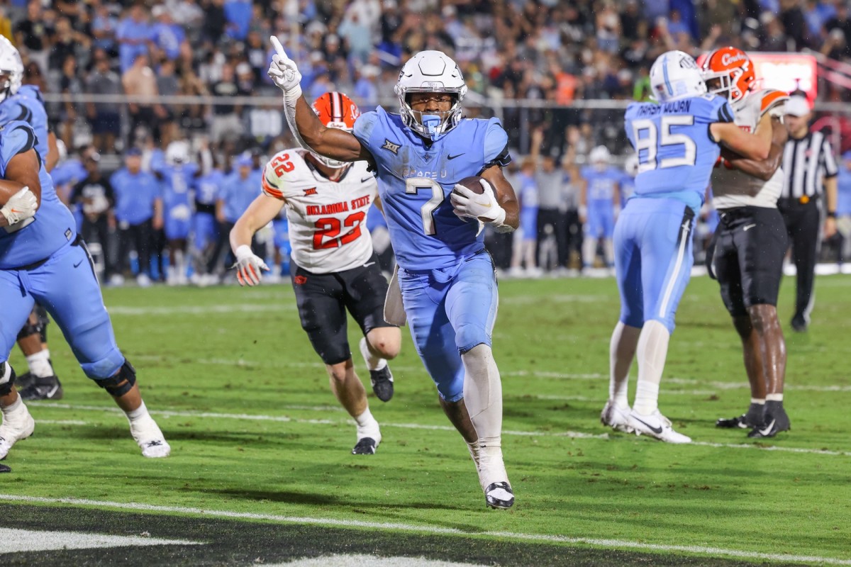 Nov 11, 2023; Orlando, Florida, USA; UCF Knights running back RJ Harvey (7) carries the ball for a touchdown during the second half against the Oklahoma State Cowboys at FBC Mortgage Stadium. 