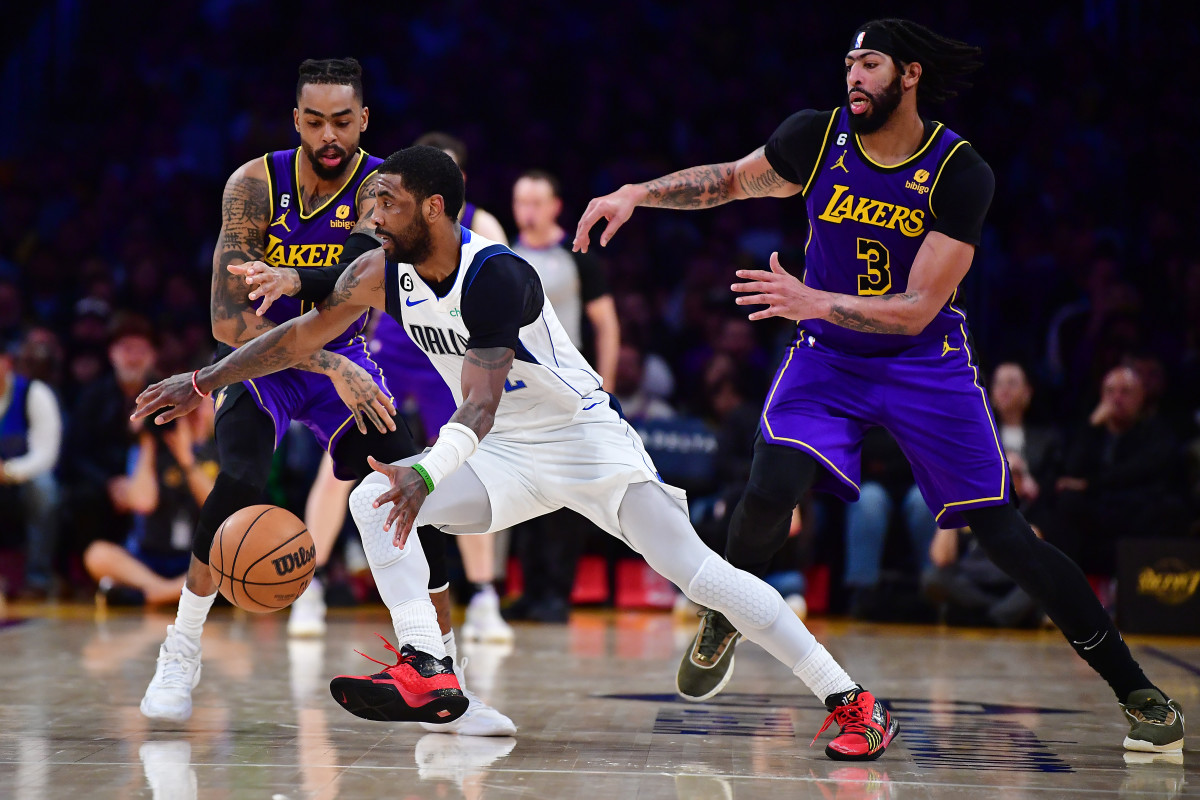 Mavs' Kyrie Irving dribbles past Lakers' Anthony Davis and D'Angelo Russell.