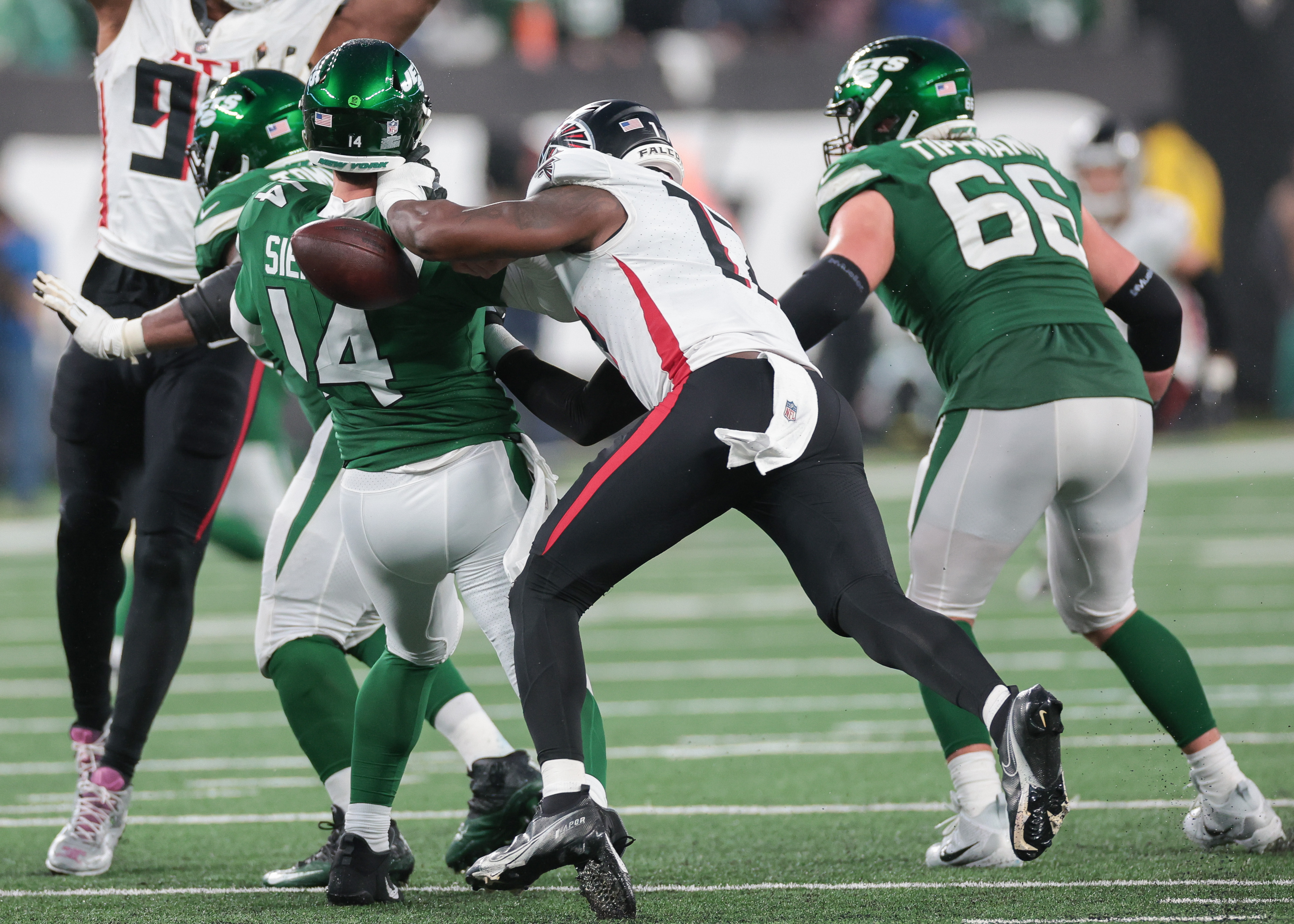 Dec 3, 2023; East Rutherford, New Jersey, USA; New York Jets quarterback Trevor Siemian (14) is hit by Atlanta Falcons linebacker Arnold Ebiketie (17) while throwing the ball during the second half at MetLife Stadium. 