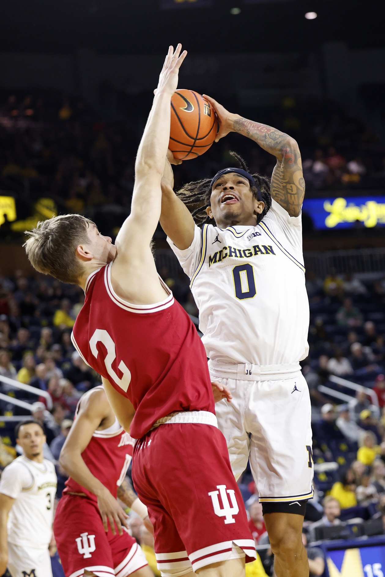 Michigan guard Dug McDaniel (0) shoots on Indiana Hoosiers guard Gabe Cupps (2).  
